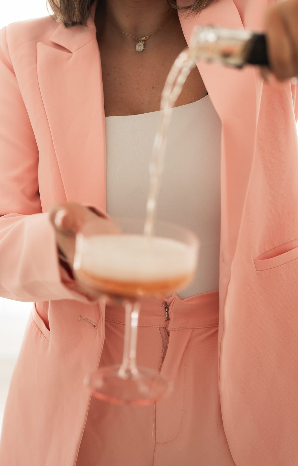 Pouring a cocktail, styled in pink